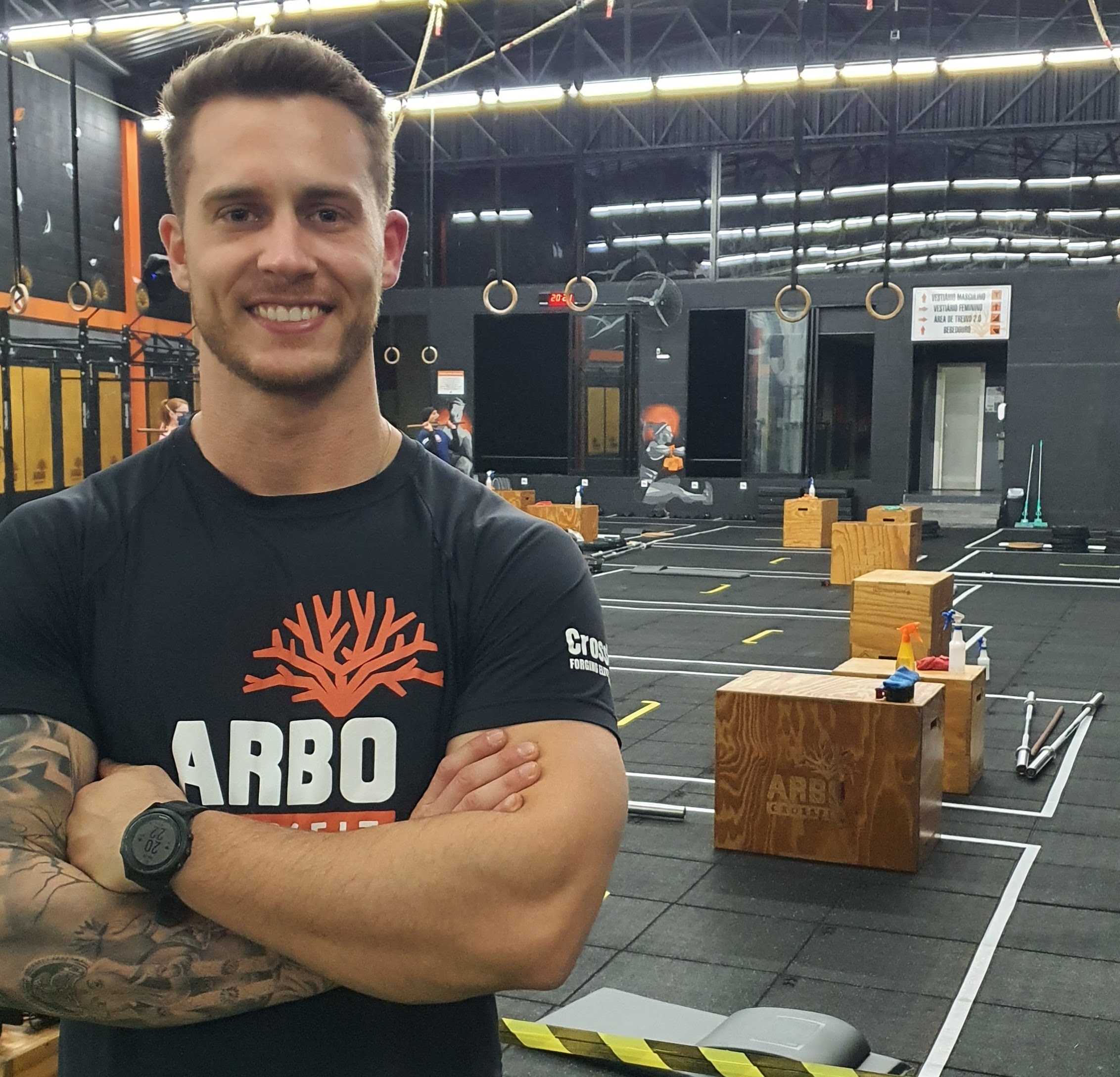 Norton Nichelle, dono de CrossFit de sucesso em Curitiba, sentado em pesos, ao lado de caixas usadas para fazer treinamento em box